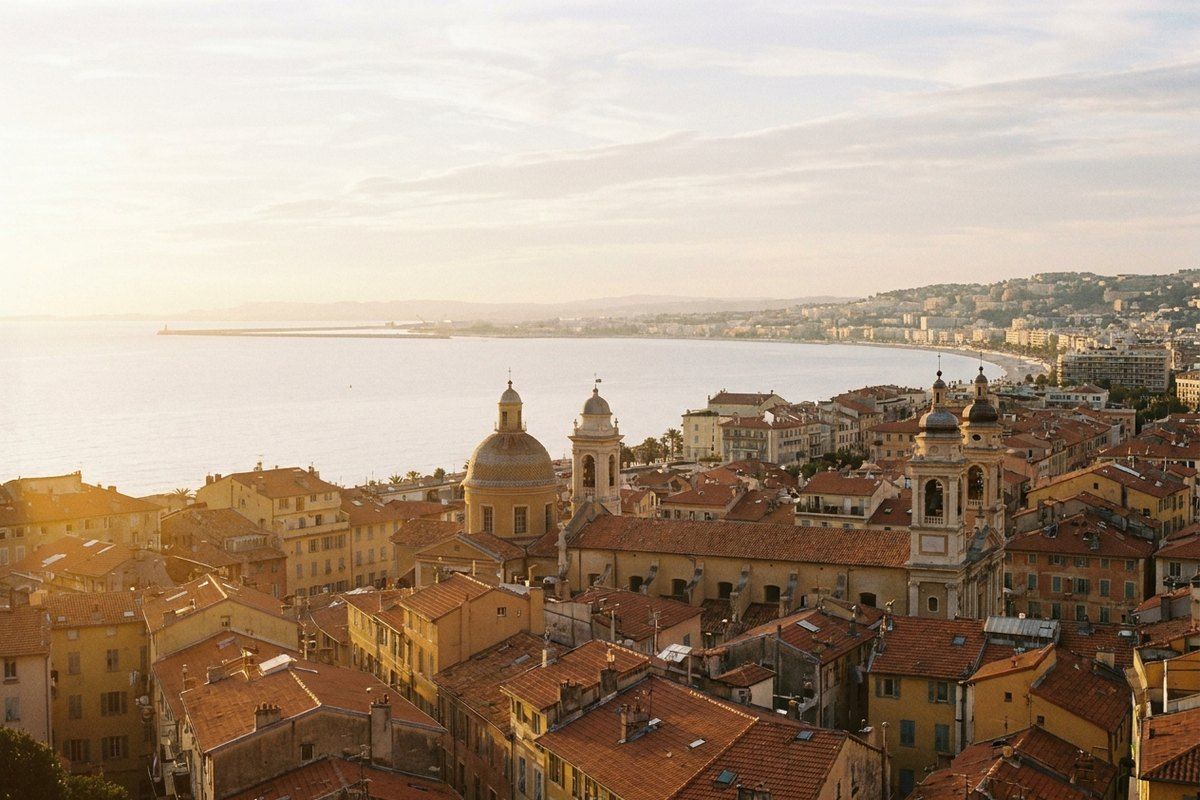 Castle Hill panorama over the terracotta rooftops of Vieux Nice and the wide sweep of the Baie des Anges in warm late-afternoon light