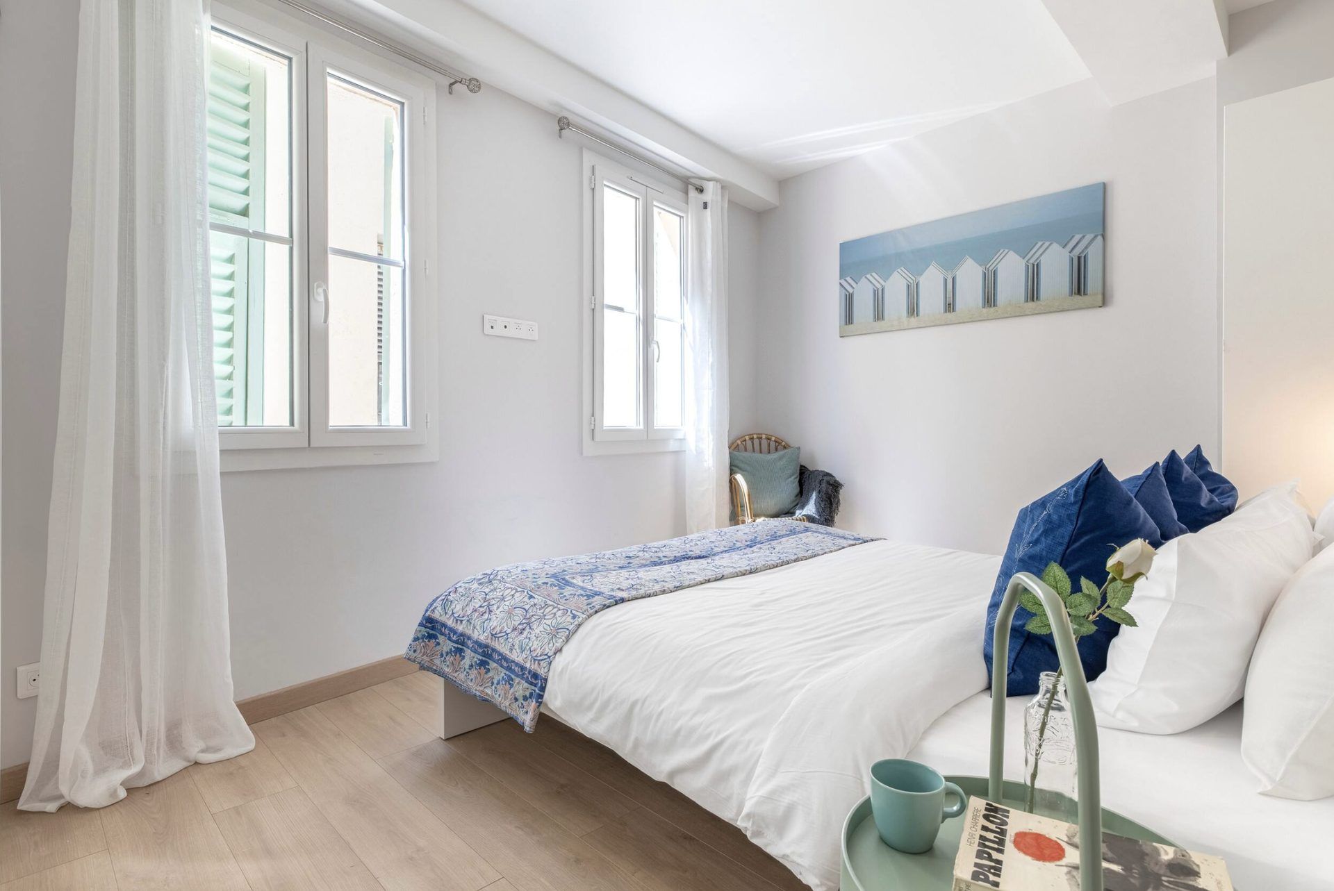 Window side of the main bedroom at Gilli, with green shutters and sheer curtains