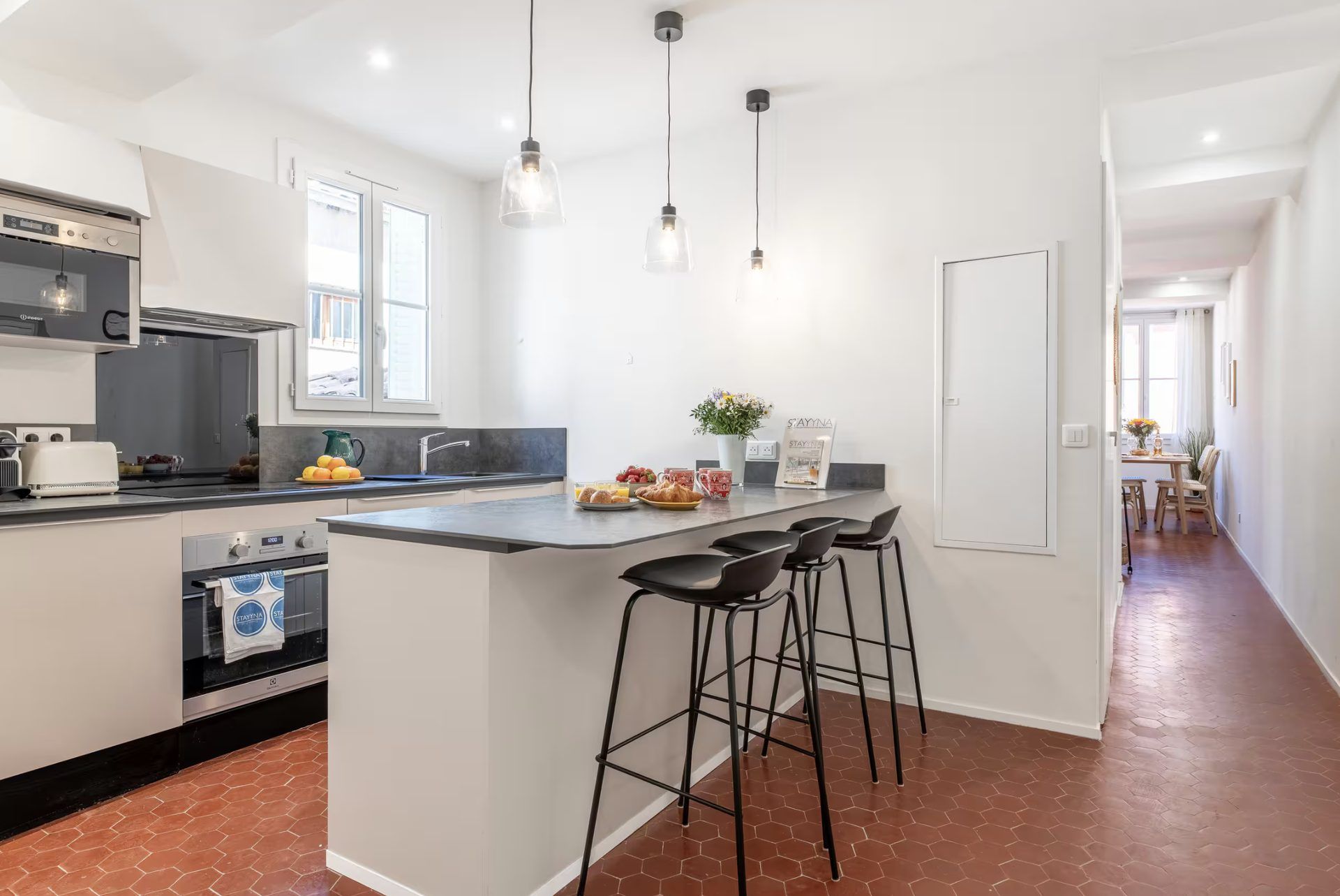Kitchen at Gilli with oven, dark stone counters, and a three-seat breakfast bar under pendant lights