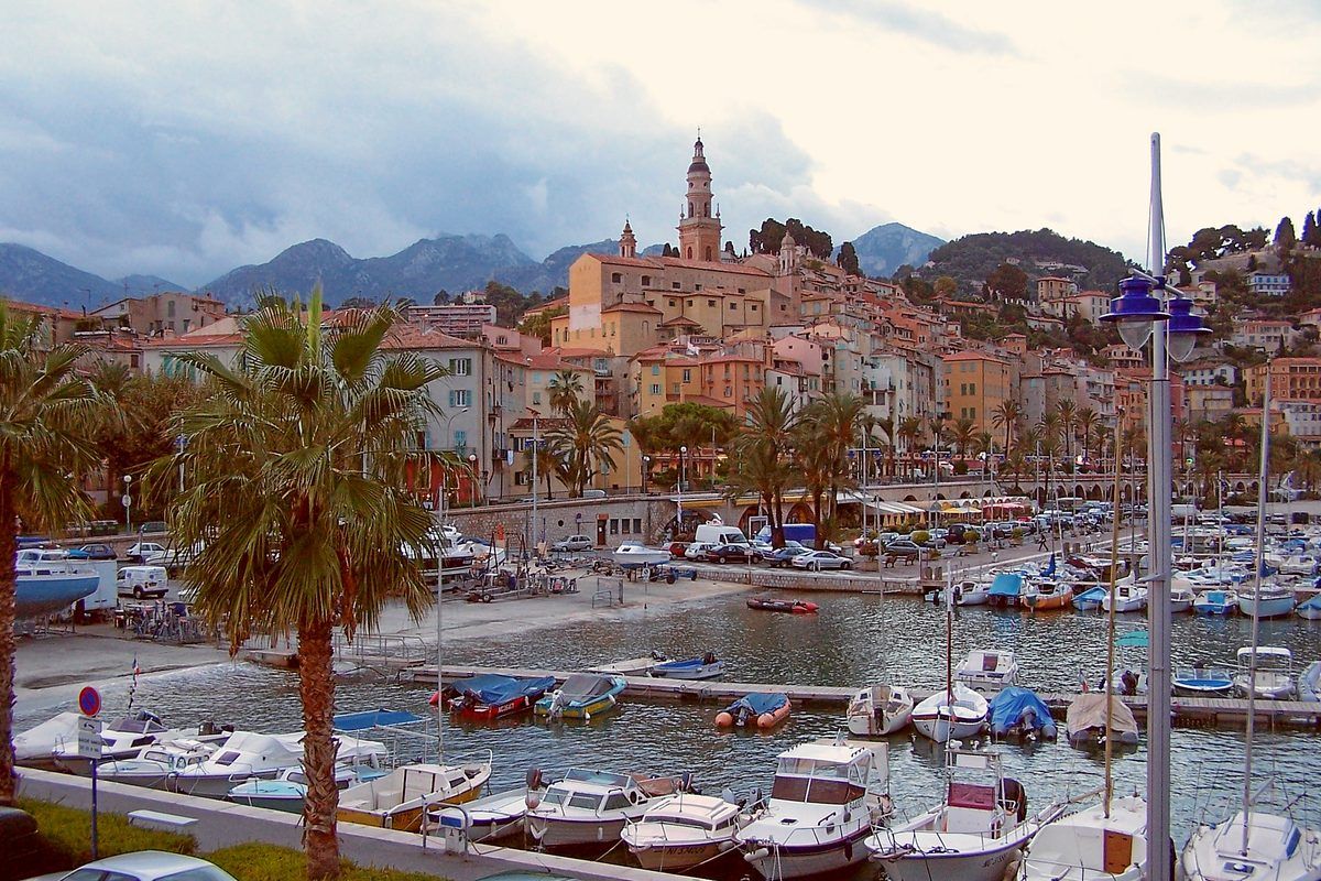 Menton's old town and harbour, pastel houses below the mountains on the French Riviera